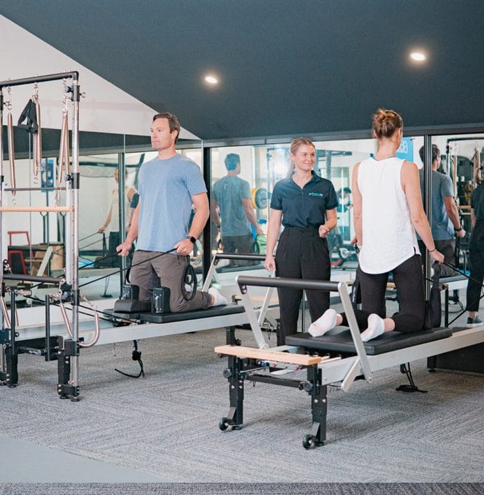 People doing clinical pilates with instructor